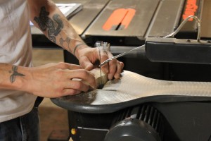 Shine works on cutting a cedar block into the shape of a tree.