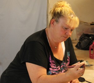 Melissa hand-draws the Sun Cedar logo on each tree.